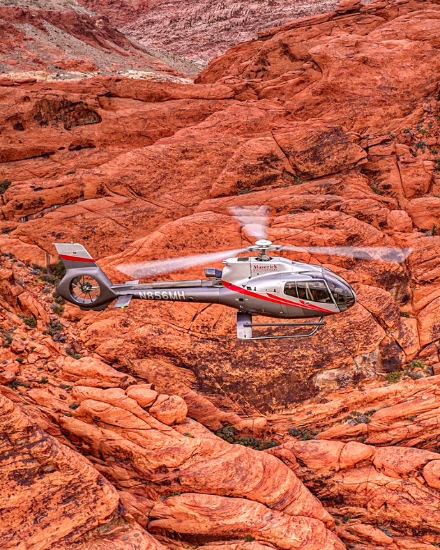 Red Rock Canyon Landing card Silver helicopter flying over red rock formations outside Las Vegas