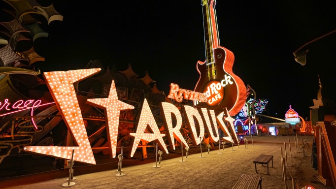 The historic illuminated neon Stardust sign and giant glowing Hard Rock Cafe guitar at night
